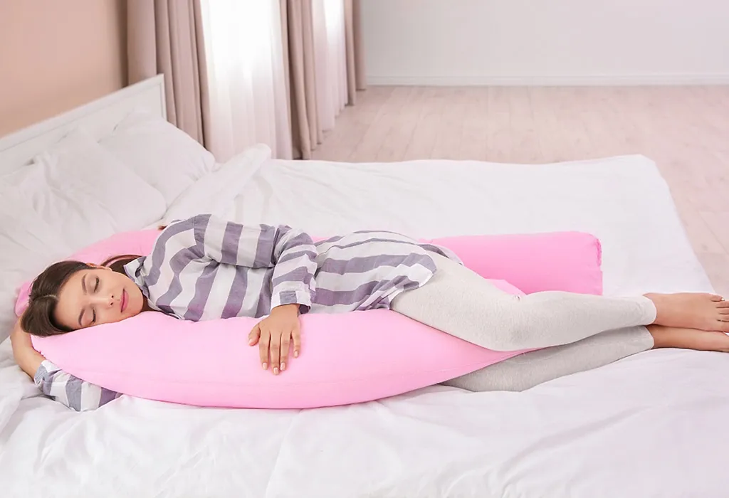 Pregnant woman sleeping on maternity pillow