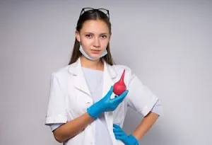 A doctor holding an enema in her hand