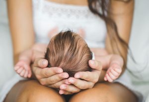 Mother supporting newborn's head and neck