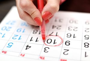 Woman marking period date on calendar