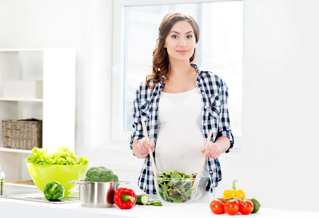 Pregnant woman making salad