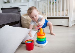 Baby trying to crawl & stand up to reach for toys