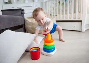 Baby trying to crawl & stand up to reach for toys