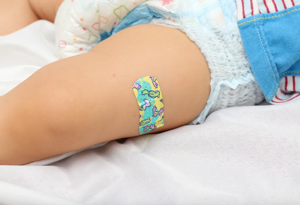 Adhesive bandage on a baby’s leg to stop bleeding after shots