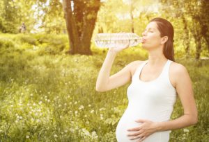 pregnant woman drinking water after exercise