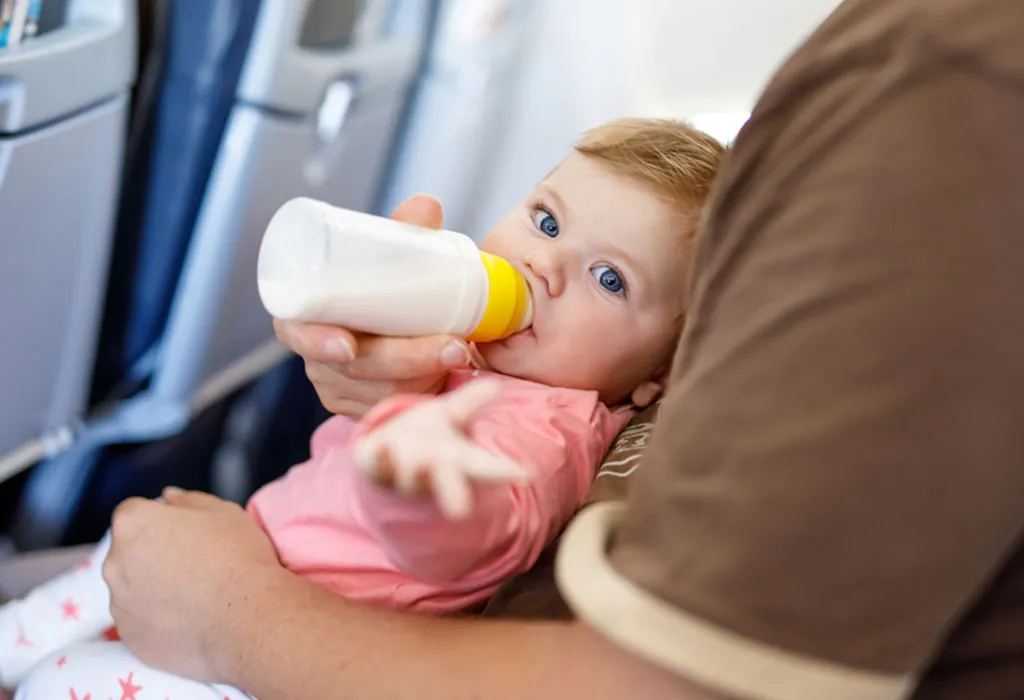 Baby in aeroplane with feeding bottle