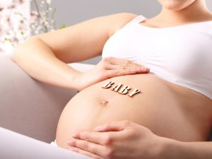 Pregnant woman massaging belly