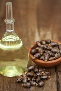 Castor oil with beans on a wooden surface
