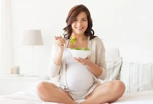 Pregnant woman eating greens