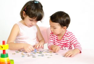 Two children solving puzzle