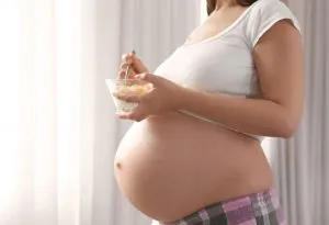 A pregnant woman eating a healthy snack