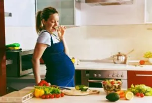 A happy pregnant woman eating a healthy meal