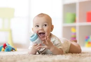 A 7-months-old baby drinking from bottle