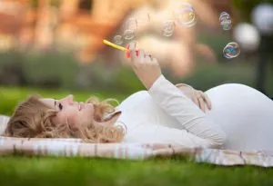 A happy pregnant woman relaxing outdoors in nature