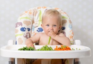 Baby eating a variety of vegetables