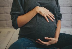 A pregnant woman holding her belly