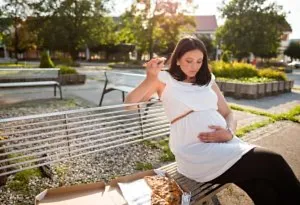 Pregnant woman eating pizza