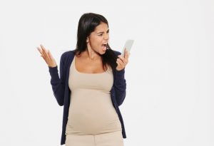 An angry pregnant woman yelling on the phone