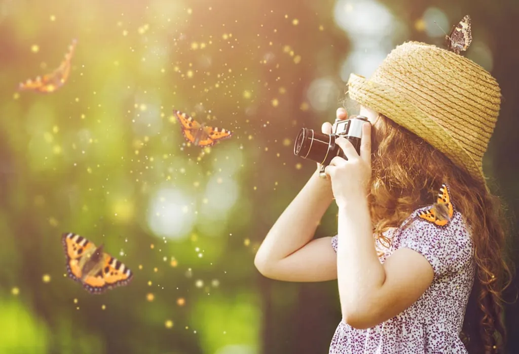 A baby looking at butterflies through a magnifying glass