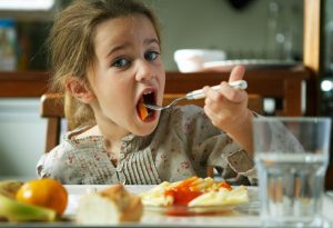 A little girl eating pasta