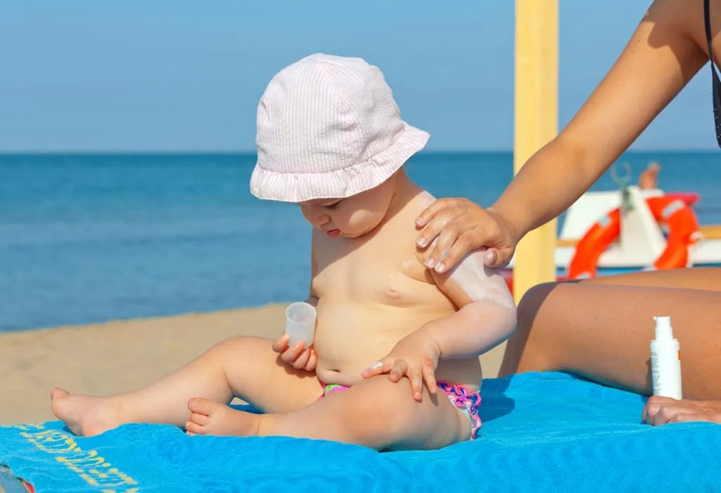 Mom puts sunscreen on her baby