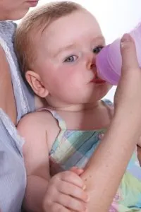 A mother giving water to her baby through a bottle