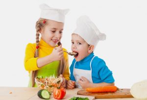 Two kids eating salad