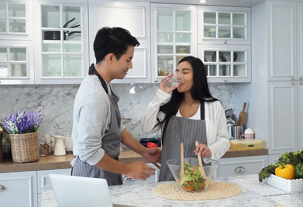 A husband cooking with his wife