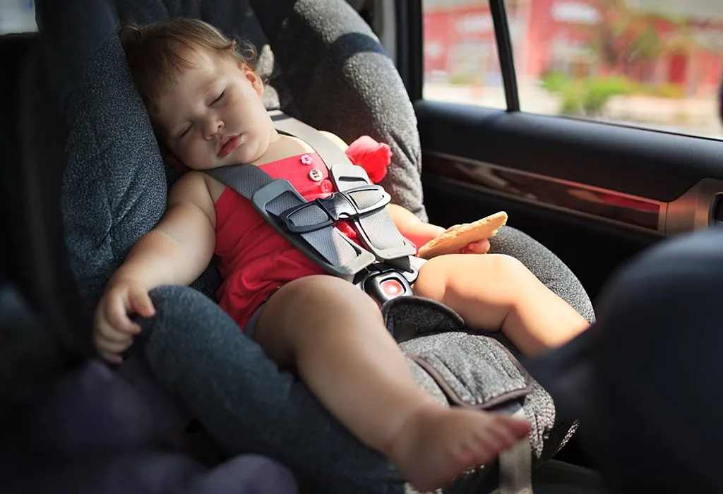 A baby girl sleeping in a car