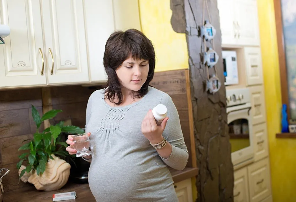 A pregnant woman taking vitamins