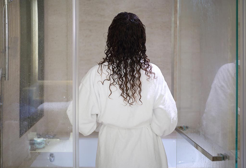  A woman in a bathrobe about to enter the bathroom
