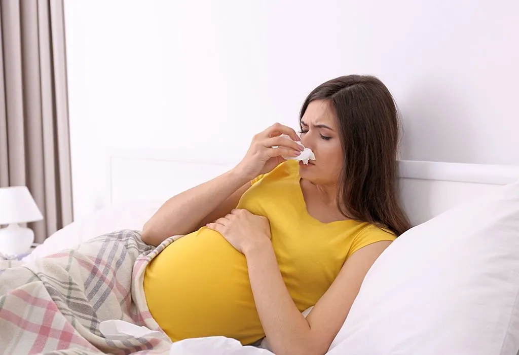 A pregnant woman sneezing