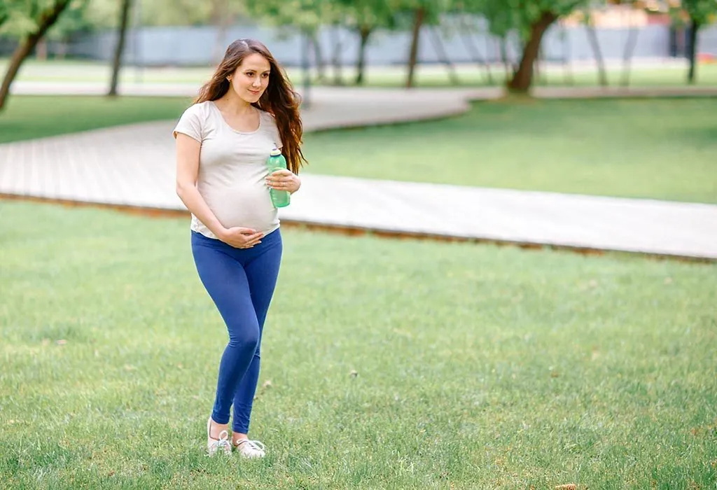 A pregnant woman walking in a park