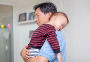 A 2-year-old sleeping on his dad's shoulders