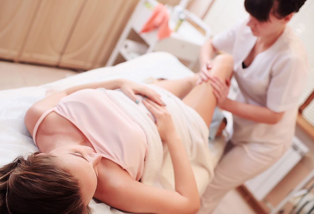 A pregnant woman getting a foot massage at a spa