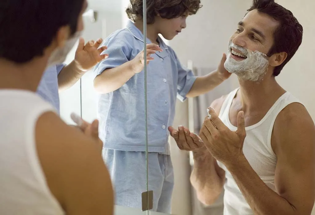 A father and son playing while shaving