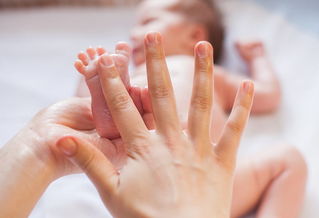 A mother massaging her baby's feet