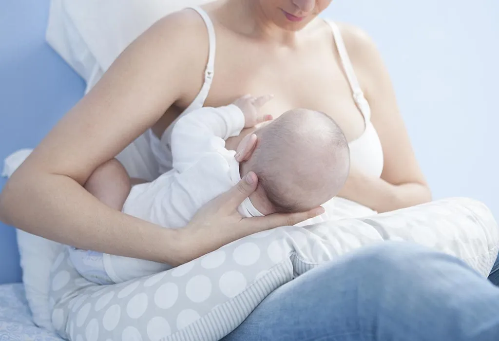 Breastfeeding a newborn using a pillow