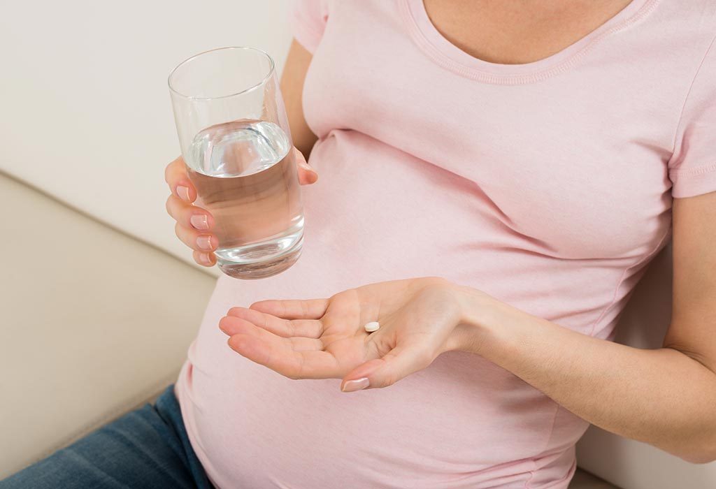 A pregnant woman taking medication.