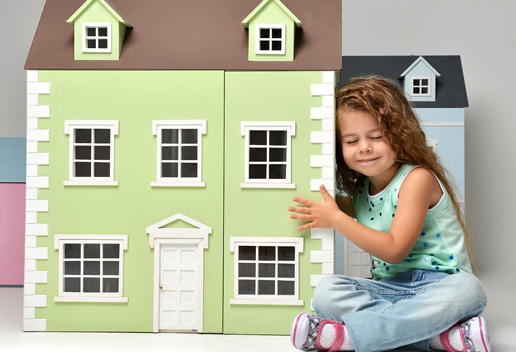 A little girl with a dollhouse