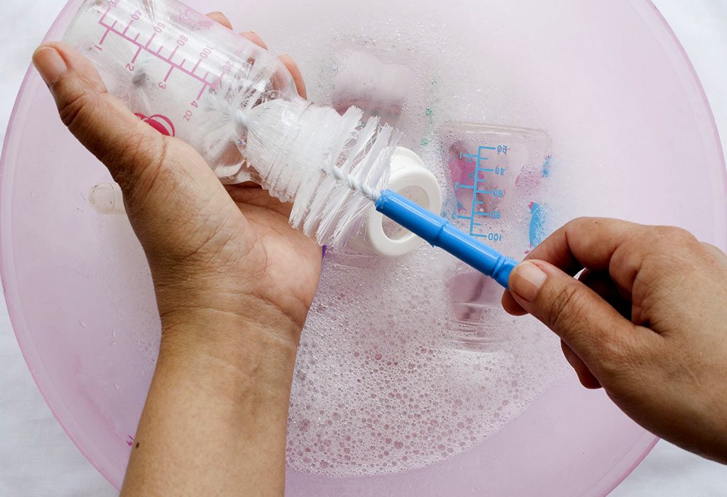 A mother cleaning a baby bottle