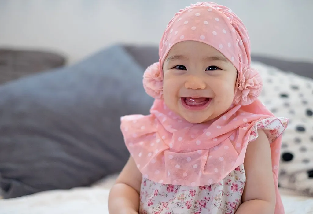 A baby wearing a pink scarf