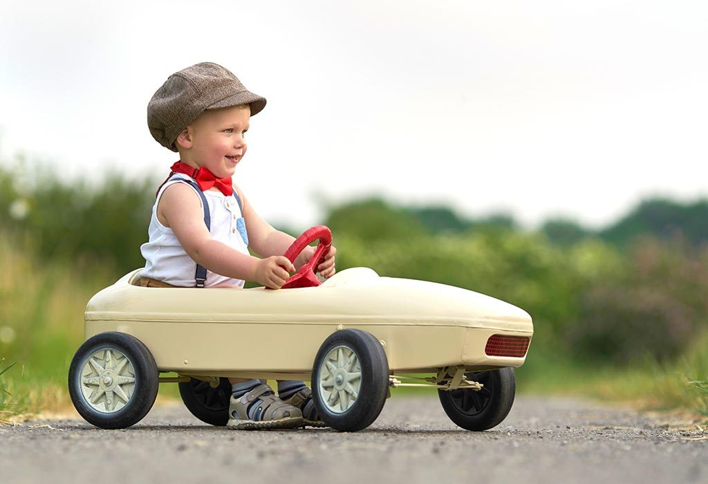 A boy driving a toy car
