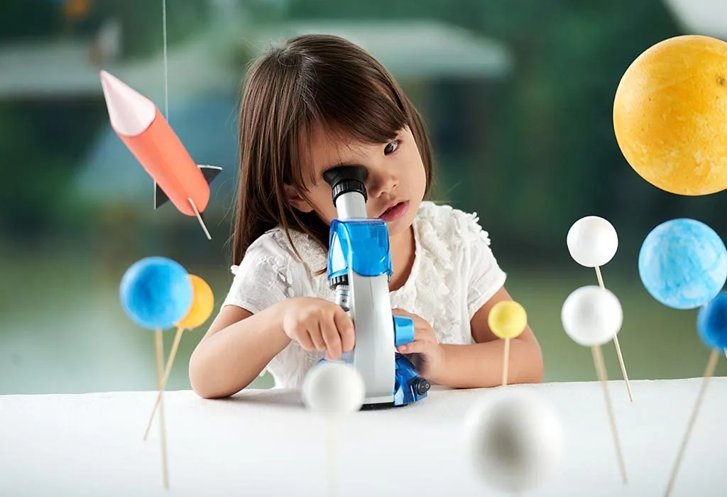 A girl playing with a toy microscope