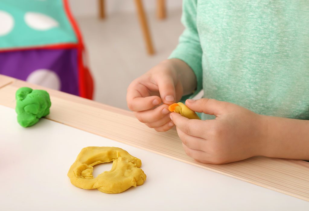 A kid using play dough
