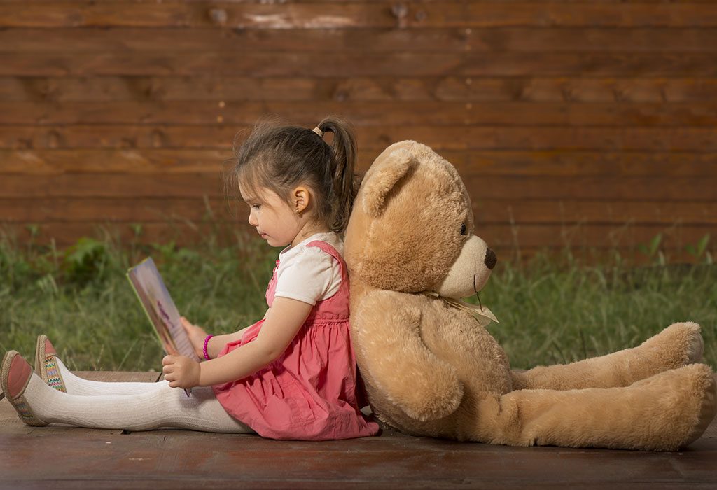 Child reading to her toy bear
