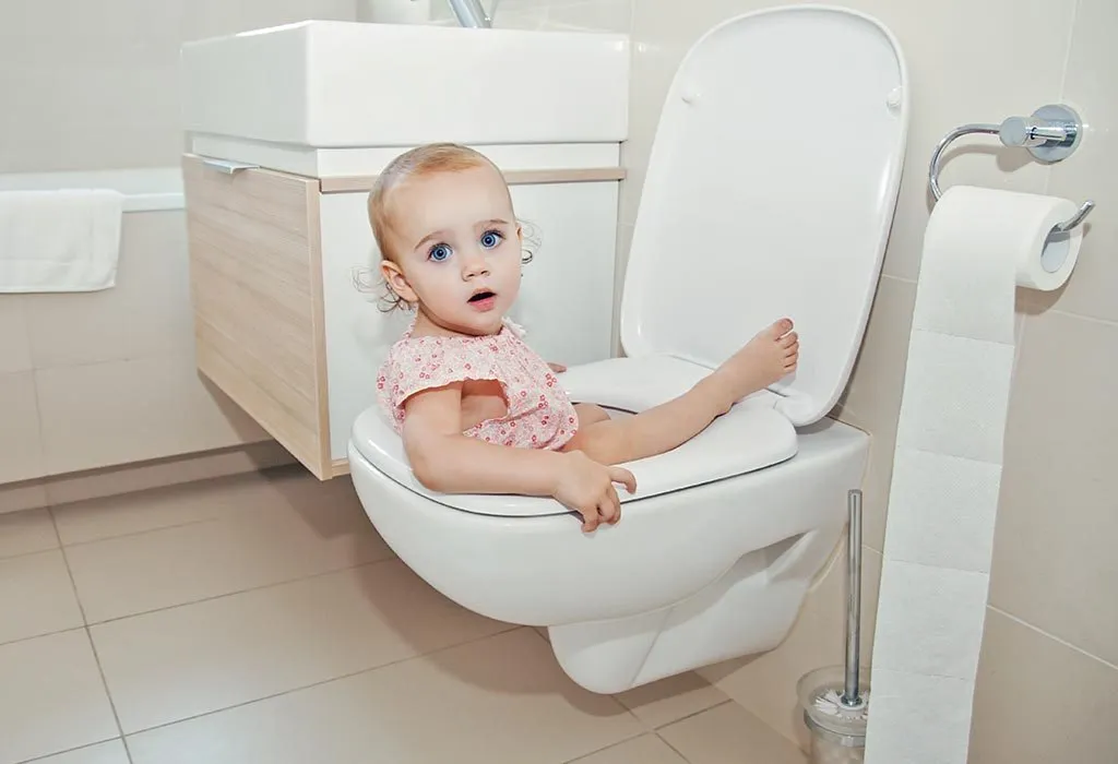 A girl falls in the toilet seat