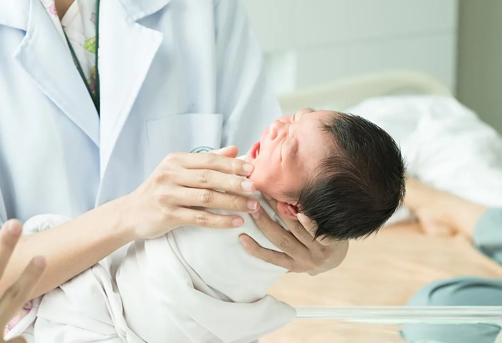 A doctor checking a crying infant