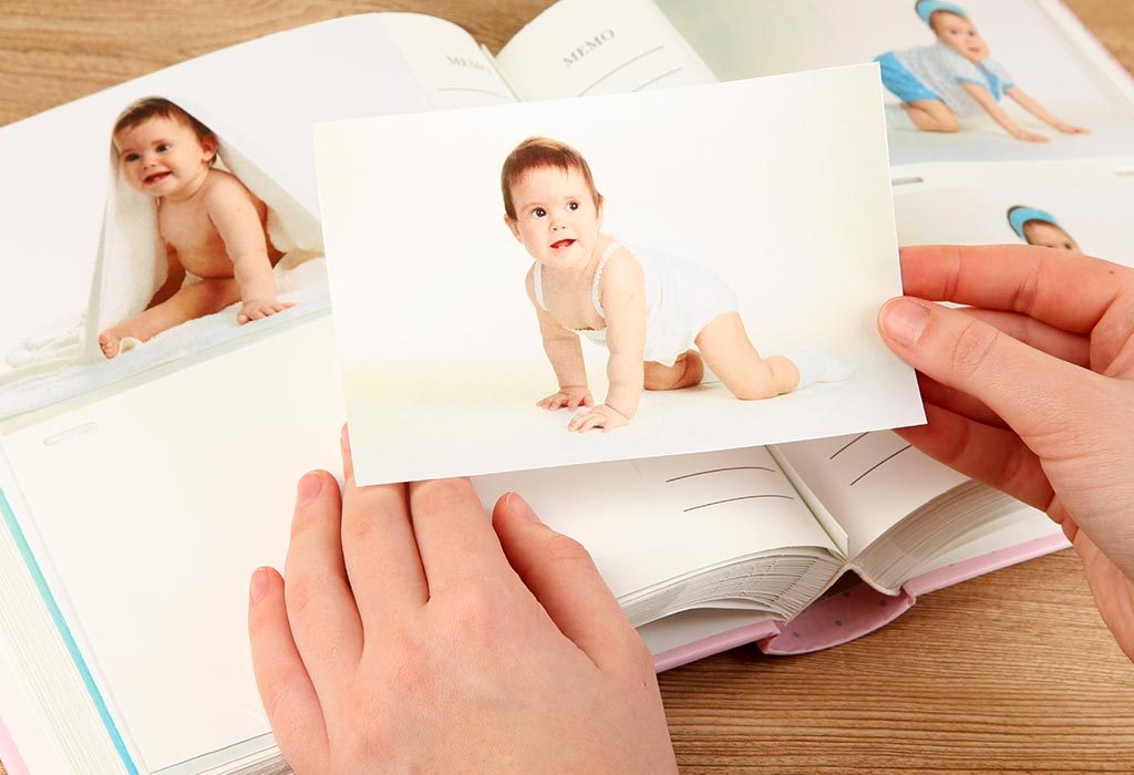 A mother sticks her baby's pictures in an album