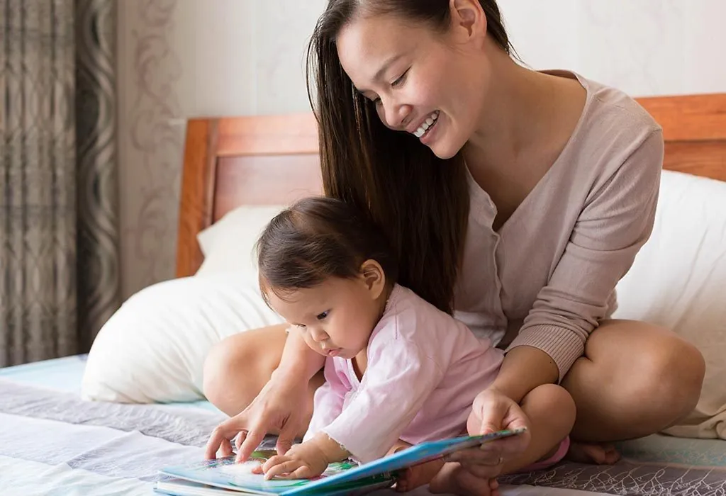 A mom and her baby with a book
